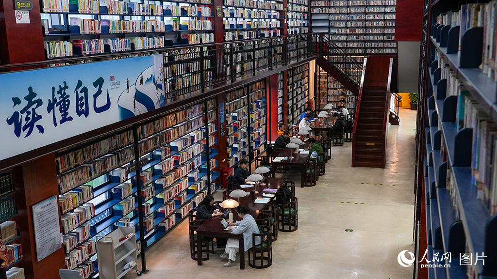 2026年4月14日，浙江省杭州市拱墅区图书馆内，几位读者或伏案疾书，或轻击键盘，或静心自习，各自沉浸在书香之中。拱墅区图书馆坚持公益普惠、全龄友好的服务理念，馆内设盲文阅览区、少儿绘本角及无障碍设施，全年无休向市民开放，让不同群体都能在家门口享受便捷、舒适的公共文化服务。人民网记者 郭扬摄