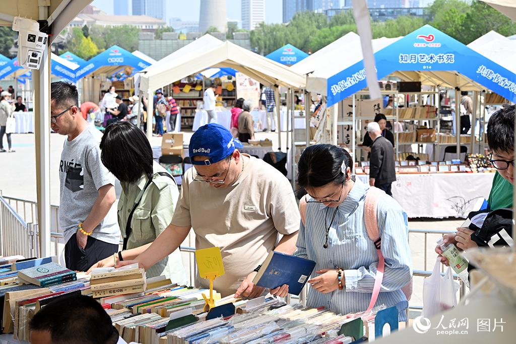 4月18日至26日，主题为“共促全民阅读，共建书香社会”的2026年海河书香节·水上公园书市活动在天津水上公园举行。图为4月18日市民正在书市上挑选喜爱的书籍。人民网记者 孙一凡摄