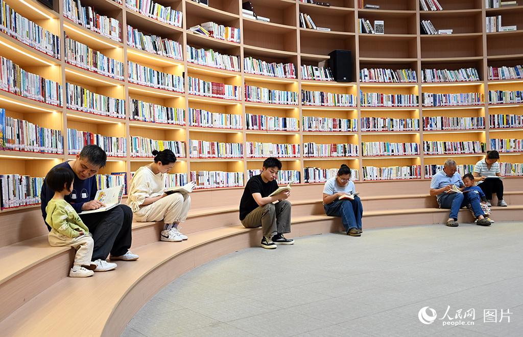2026年4月17日，河南省郑州市郑东新区如意湖边的“郑品书舍”城市书房，市民在免费阅读。近年来，郑州市依托馆藏资源丰富的各地公共图书馆与遍布全市的89座“郑品书舍”城市书房、191个图书馆乡镇（街道）分馆、2049个标准农家书屋以及637家职工书屋示范点，共同织就了一张立体化、普惠均等的公共阅读服务网络，逐渐形成了“15分钟阅读圈”。人民网记者 王玉兴摄